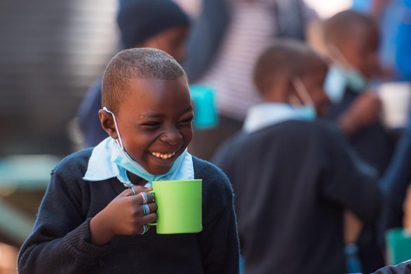 young boy at kicoshep school enjoying a porridge breakfast