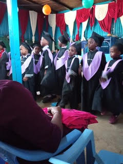 students at kindergarten graduation in cap and gown
