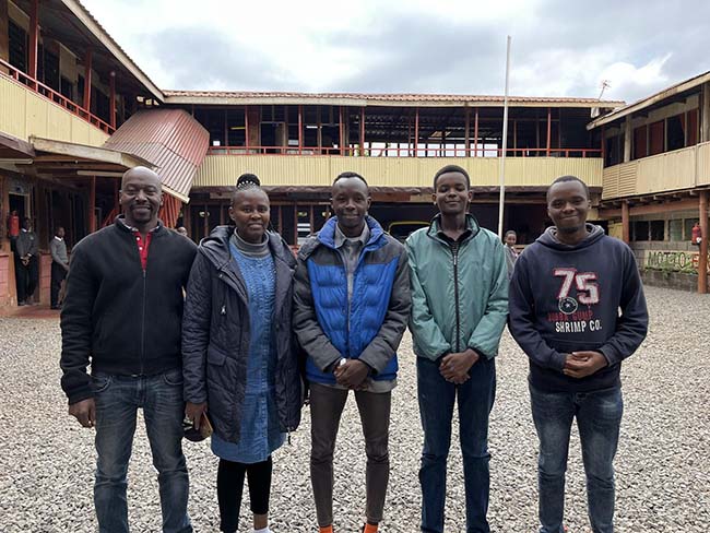 university students visiting their old school and their teachers