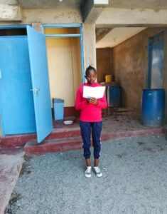 abigail holding their thank you note in a classroom