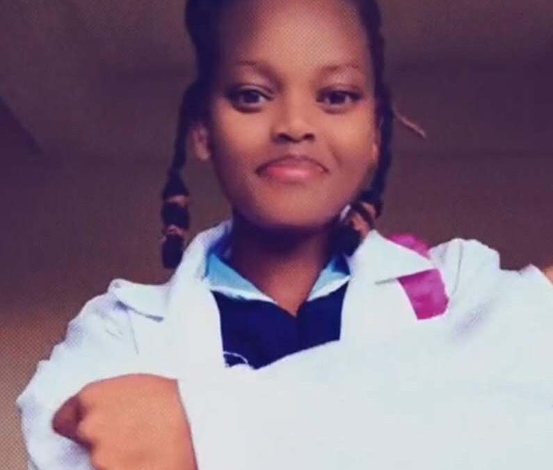 young kenyan worker smiling while wearing a doctor's coat