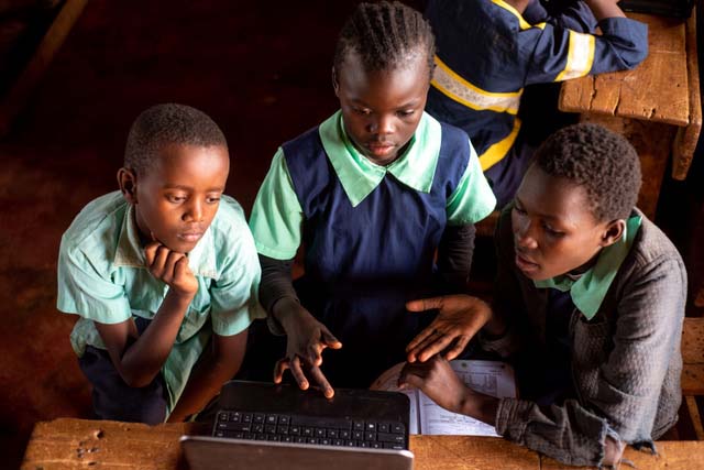 group of students working on a laptop on an assignment